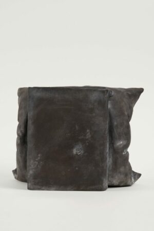 Günther Uecker Skulptur Kissenbuch dunkel. Das Original Kunstwerk stammt aus dem Jahr 1969, 2021 wurde diese Bronze im Format 27 x 34 x 29 cm